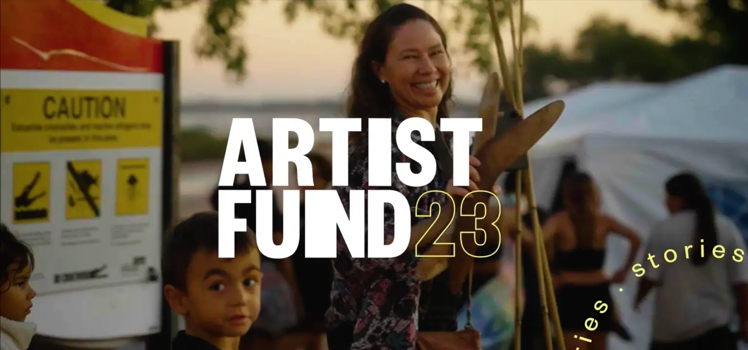 Tara Gower smiling at the camera, at a public open space at sunset. The Artist Fund 23 logo is over the top of the image.