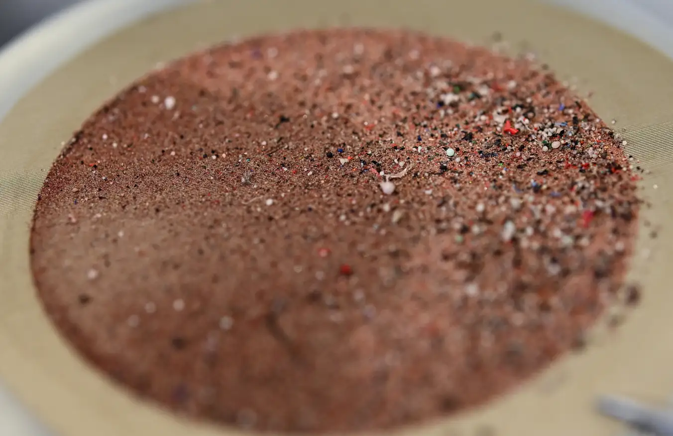 A close up of microplastics particles on a stainless steel membrane.